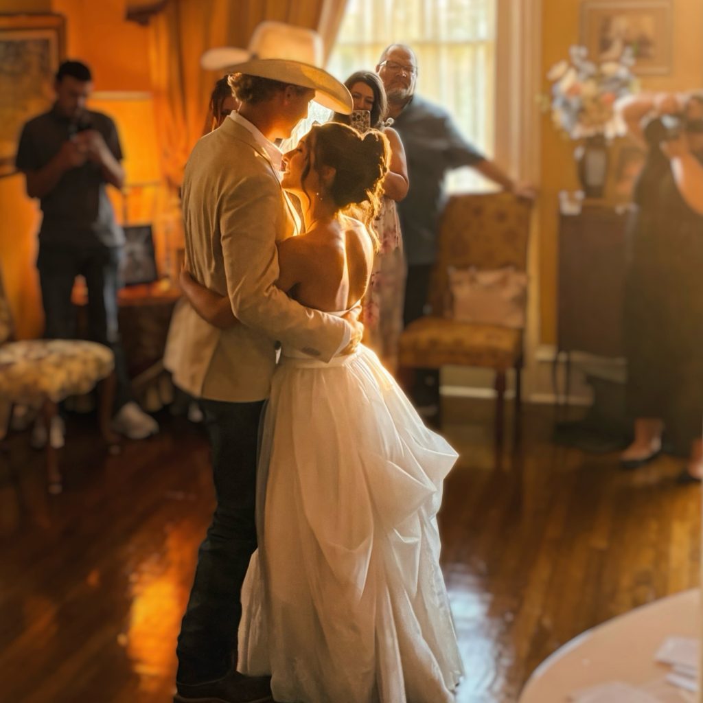 A bride and groom dancing in warm golden light