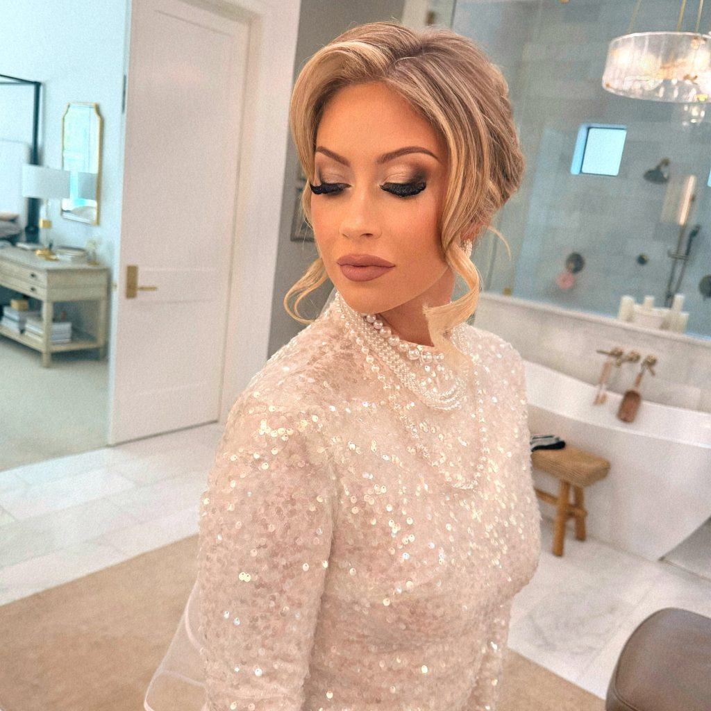 Luminous bridal makeup with gold eyeshadow and a softly styled blonde updo