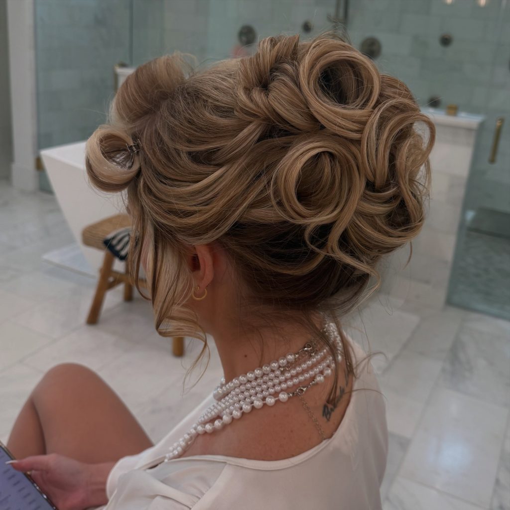 Detailed blonde bridal updo with softly arranged loops and curls