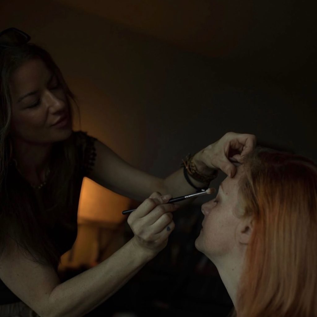A makeup artist blending eyeshadow during wedding preparation